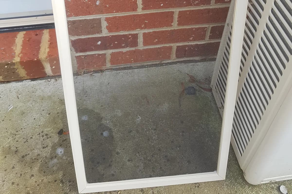 Recent job in Highton: a flyscreen removed from its window and leaning against a brick wall for cleaning